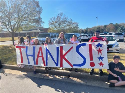 students holding a large banner that says Thanks